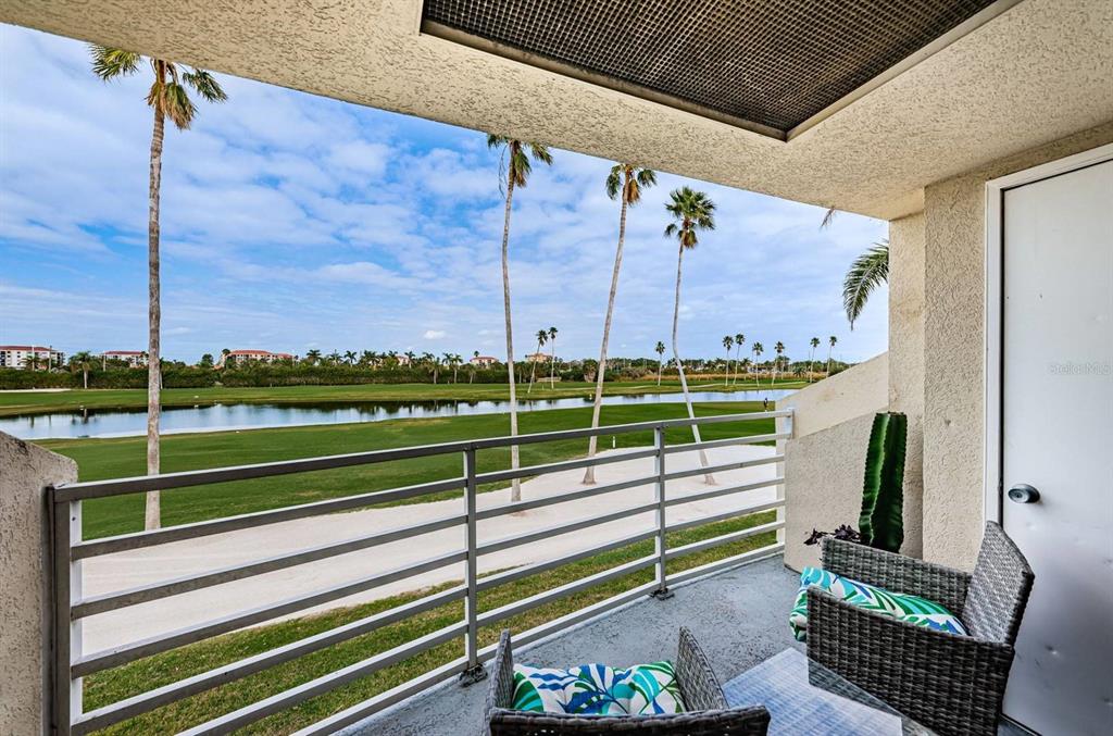 A balcony with a metal railing overlooks a golf course, a pond, and palm trees — 6141 BAHIA DEL MAR BOULEVARD UNIT 229, ST PETERSBURG, FL