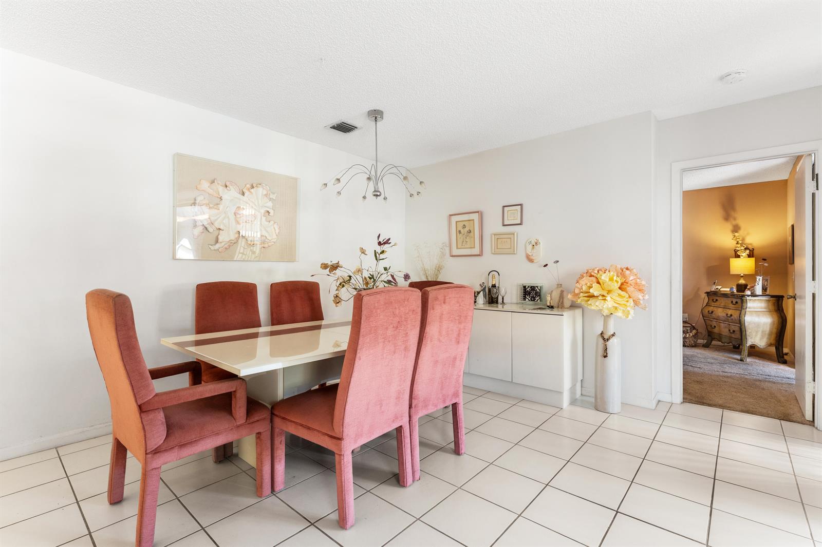 A dining room features a white table, six pink upholstered chairs, and white tile flooring — 5226 Europa Drive # G, Boynton Beach FL 33437, BOYNTON BEACH, FL