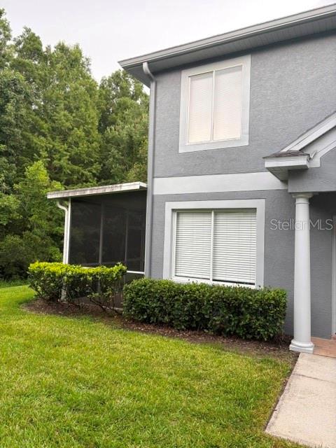 A two-story gray stucco house features a screened-in porch and a white column — 18157 PARADISE POINT DRIVE, TAMPA, FL