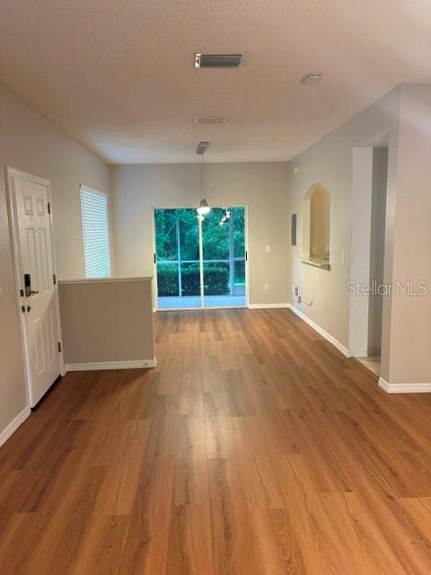 An open living area features wood-look flooring, a sliding glass door, and a partial wall — 18157 PARADISE POINT DRIVE, TAMPA, FL