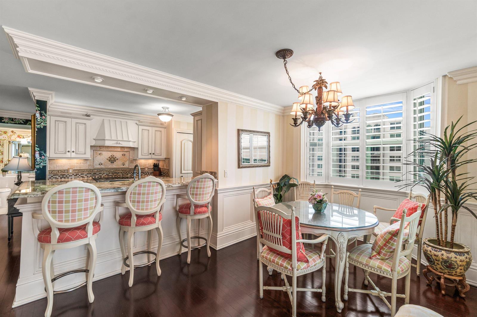 A kitchen with a breakfast bar and dining area featuring a chandelier and bay windows — 3594 S Ocean Boulevard # 801, Highland Beach FL 33487, HIGHLAND BEACH, FL