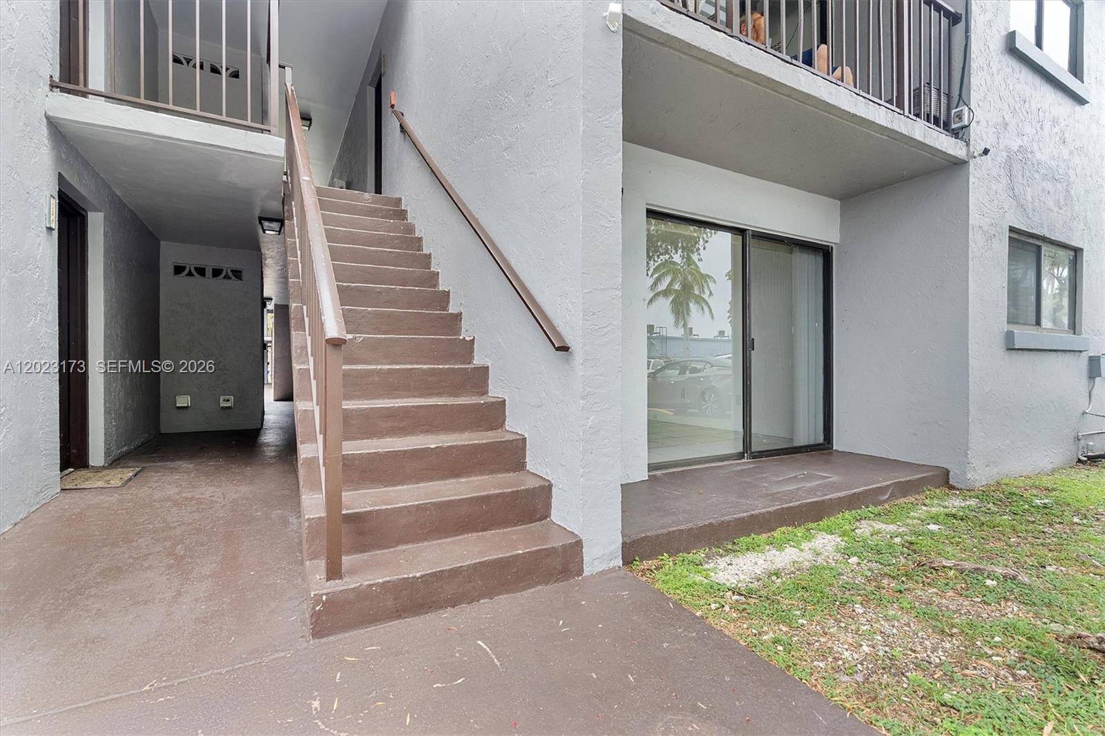 An exterior view shows a concrete staircase leading to an upper level beside a patio — 7407 SW 152nd Ave # 103, Miami FL 33193, MIAMI, FL