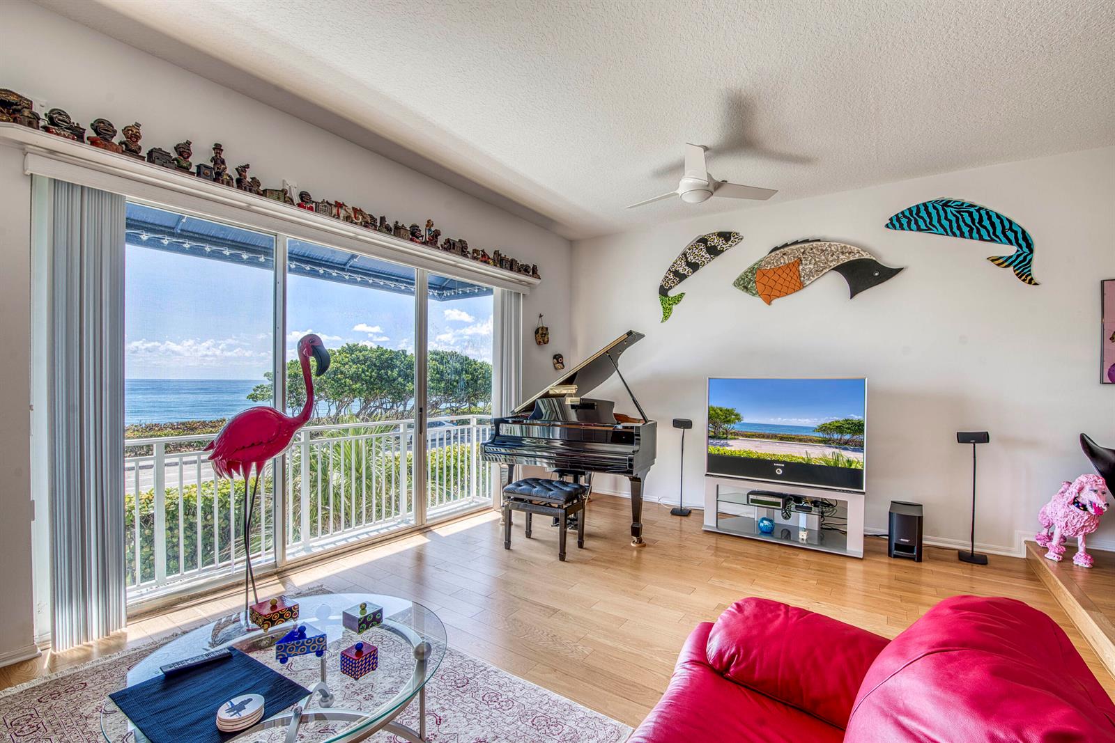 A living room features a grand piano, a television, and a view of the ocean — 115 Ocean Key Way, Jupiter FL 33477, JUPITER, FL