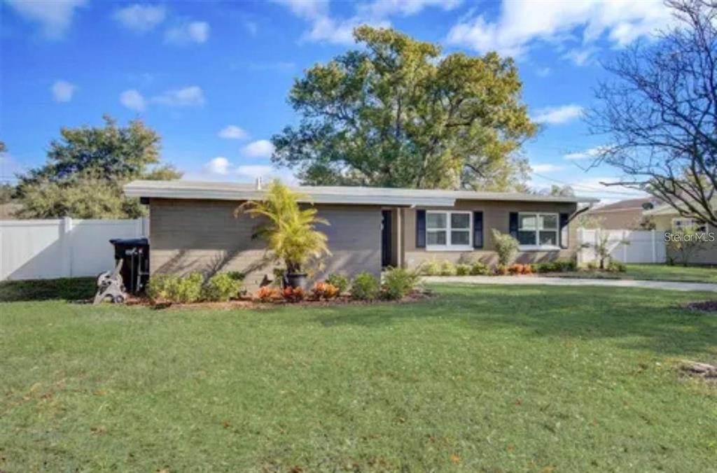 A single-story house with a brown exterior, white trim, and a large front lawn — 5205 CHENAULT AVENUE, ORLANDO, FL