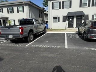 A silver pickup truck and a dark SUV are parked in marked resident parking spaces — 1134 RUE DES ROIS UNIT 1134, ST PETERSBURG, FL