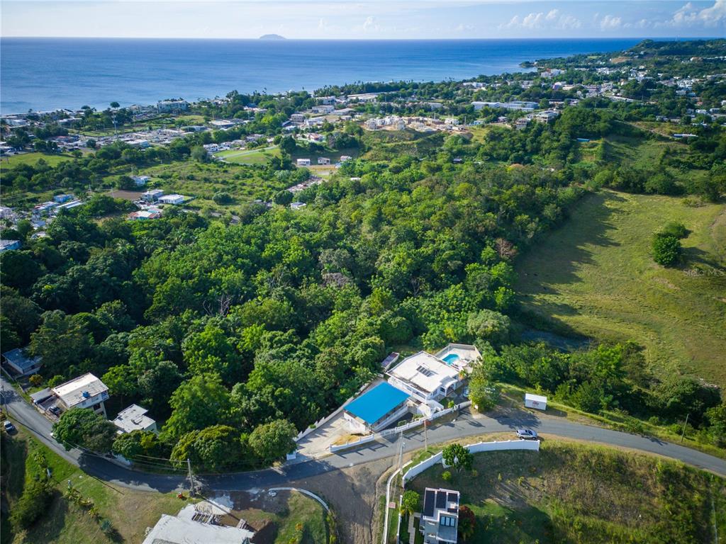 An aerial view shows a house with a blue roof and pool near a coastline — Carr. 115 KM 11.4 INT SECTOR JULIO SOTO, RINCON, PR