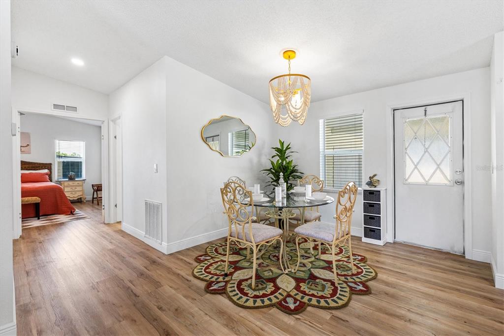 A dining area with a glass table, four ornate chairs, and a patterned rug — 1616 BAYHILL DRIVE, LADY LAKE, FL