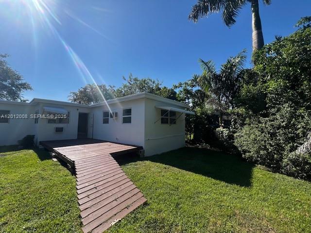 A white house exterior features a wooden deck and ramp leading to the backyard — 4548 SW 33rd Ave # M, Dania Beach FL 33312, DANIA BEACH, FL