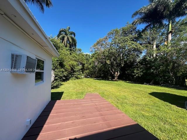 A wooden deck extends from the side of a white house toward a grassy yard — 4548 SW 33rd Ave # M, Dania Beach FL 33312, DANIA BEACH, FL