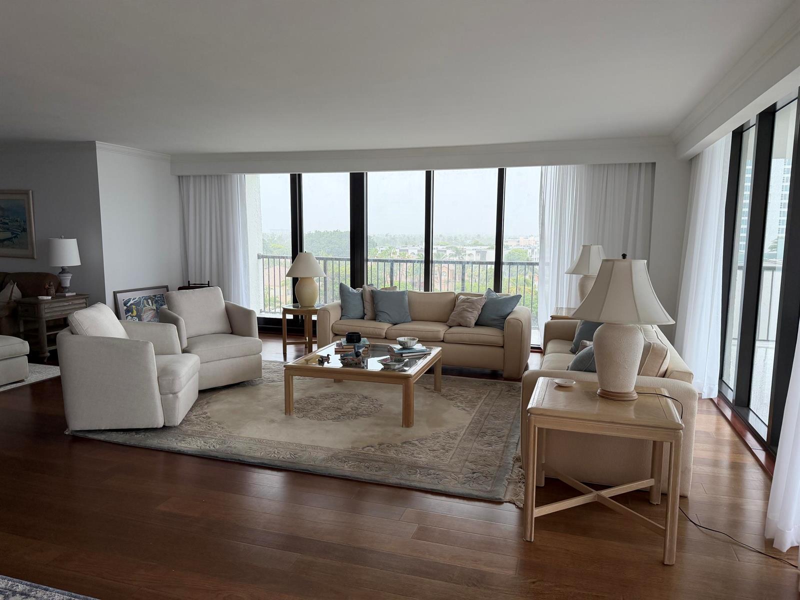 A living room features beige furniture, a glass coffee table, and floor-to-ceiling windows with views — 1800 S Ocean Boulevard Unit 612, Pompano Beach FL 33062, POMPANO BEACH, FL