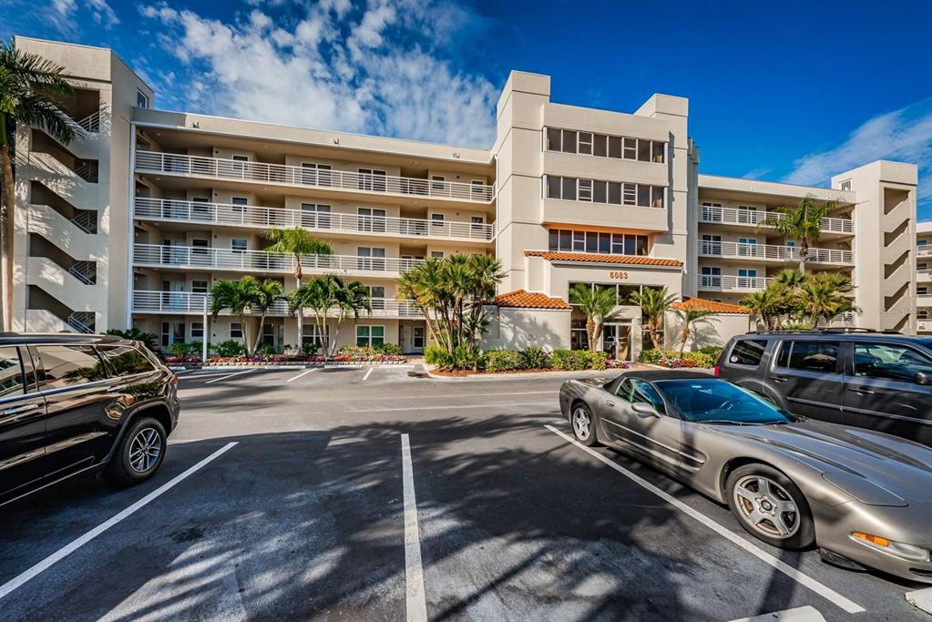 A multi-story apartment building with balconies and a parking lot in the foreground — 6083 BAHIA DEL MAR CIRCLE UNIT 460, ST PETERSBURG, FL