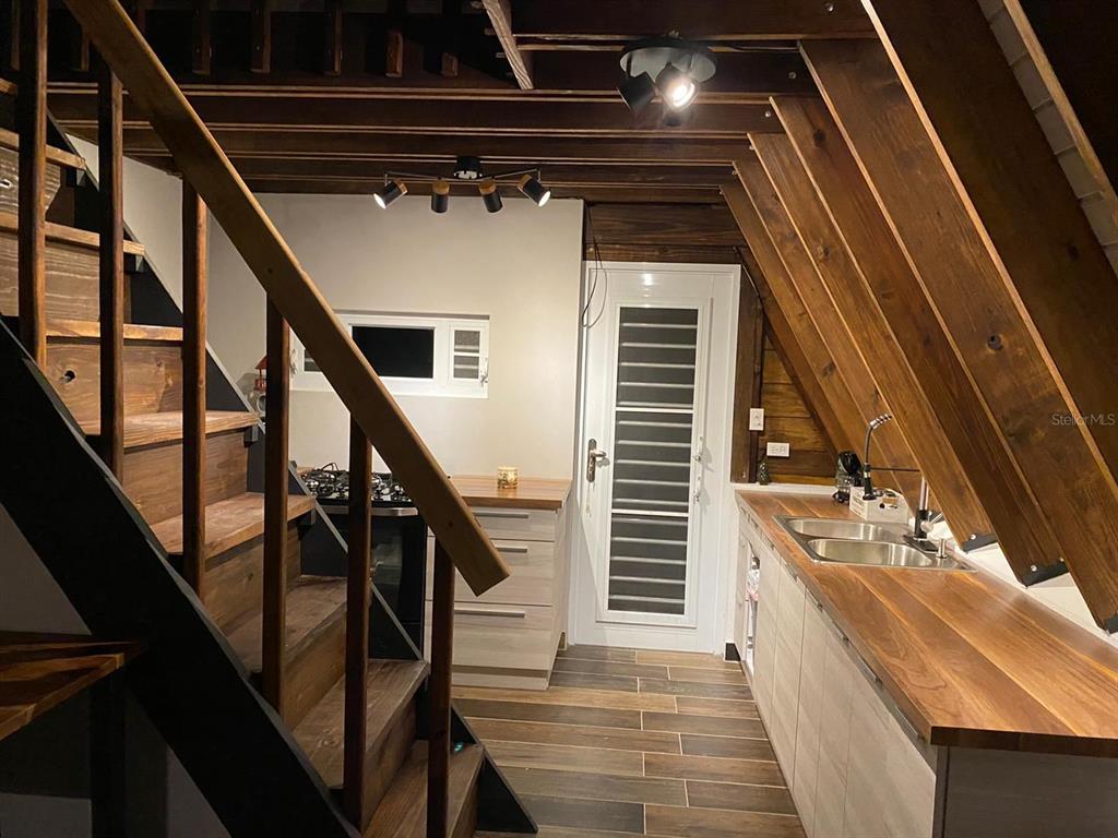 A kitchen with wood countertops and stairs is situated inside an A-frame structure — 717 CARR. 717, 4.2 INT, LOT 5, AIBONITO, PR
