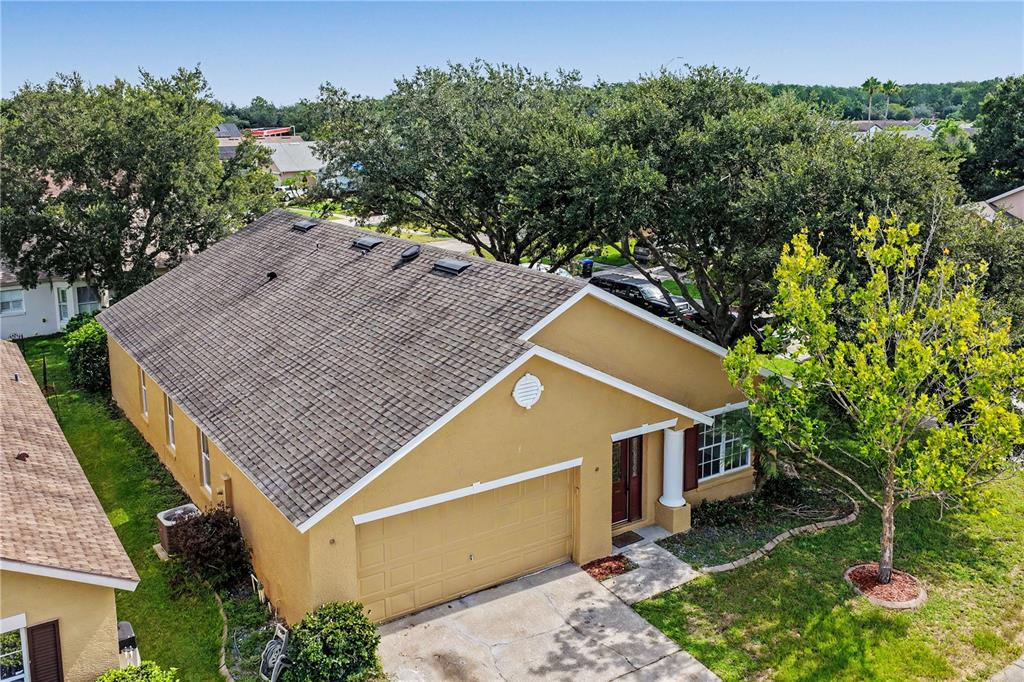 An aerial view of a tan single-story house with a two-car garage and shingled roof — 544 CYPRESS TREE COURT, ORLANDO, FL