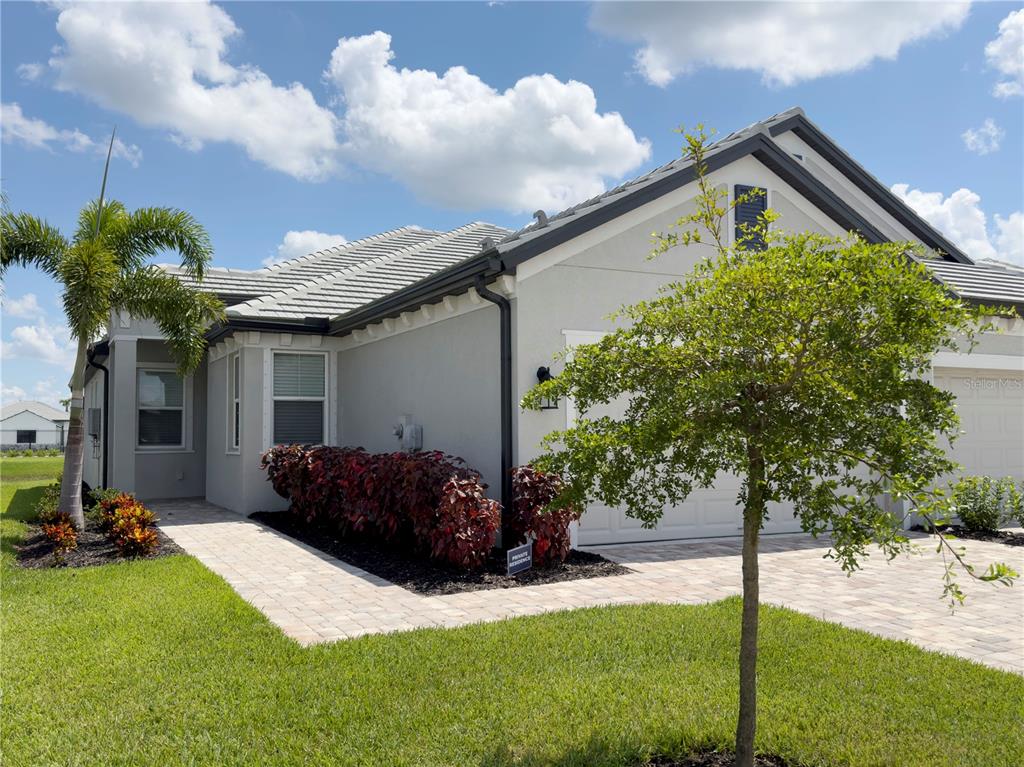 A one-story house with a light-colored exterior, a paved driveway, and a small front yard — 17881 CHERISHED LOOP, BRADENTON, FL