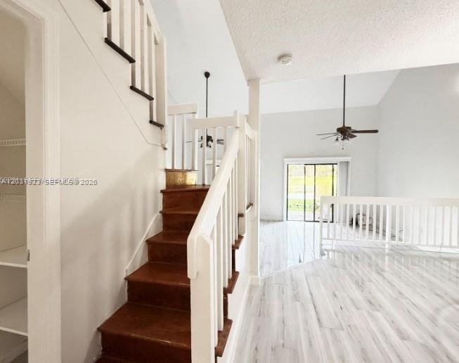 A staircase with wooden treads leads to an upper level in a bright living area — 4182 S Pine Island Rd, Davie FL 33328, DAVIE, FL