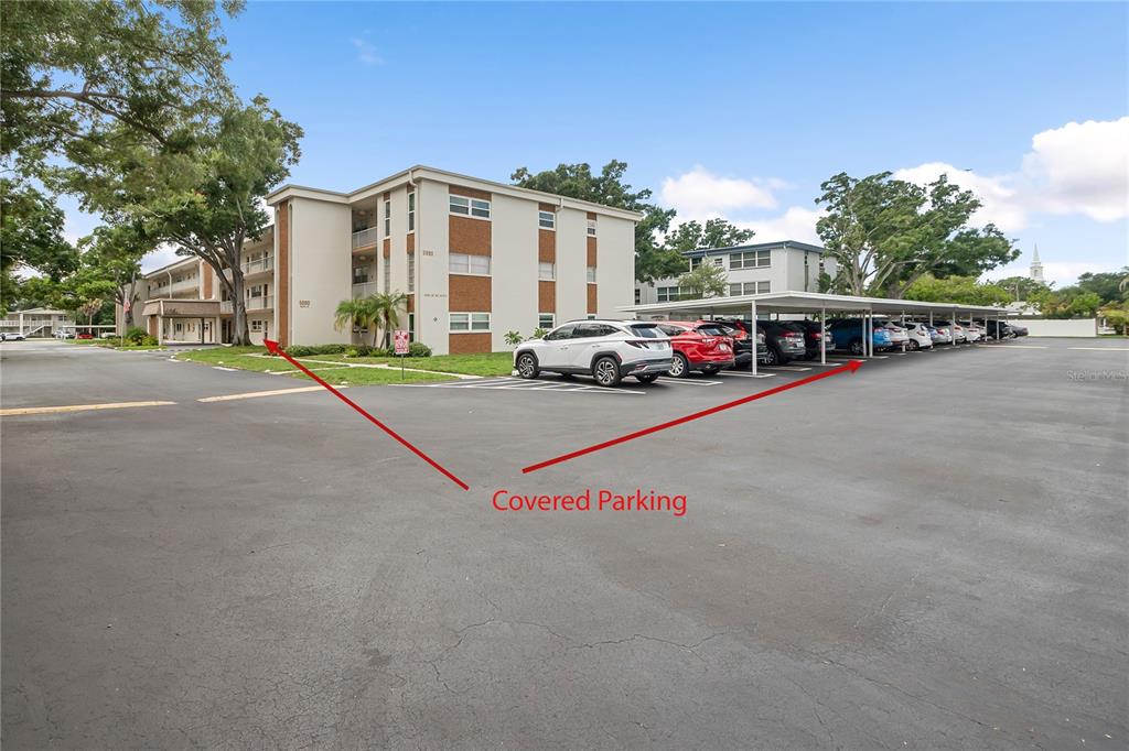 An exterior view of a multi-story apartment building with a large asphalt parking lot — 5880 38TH AVENUE N UNIT 109, ST PETERSBURG, FL