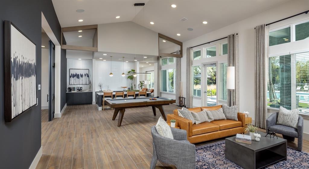 A spacious room features a pool table, a leather sofa, and a kitchen area — 10881 CALADESI AVENUE UNIT B2, TAMPA, FL