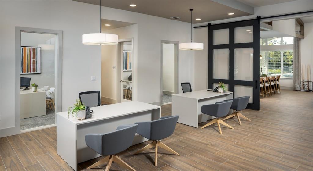 A modern office space features two white desks, gray swivel chairs, and a sliding barn door — 10881 CALADESI AVENUE UNIT B2, TAMPA, FL