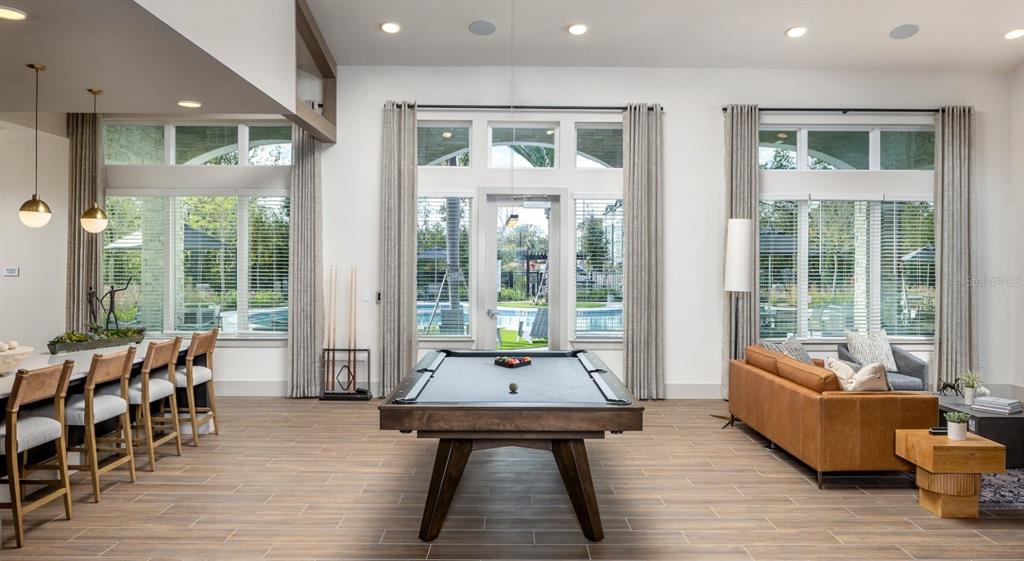 A spacious game room features a pool table, bar seating, and a leather sofa — 10881 CALADESI AVENUE UNIT B2, TAMPA, FL