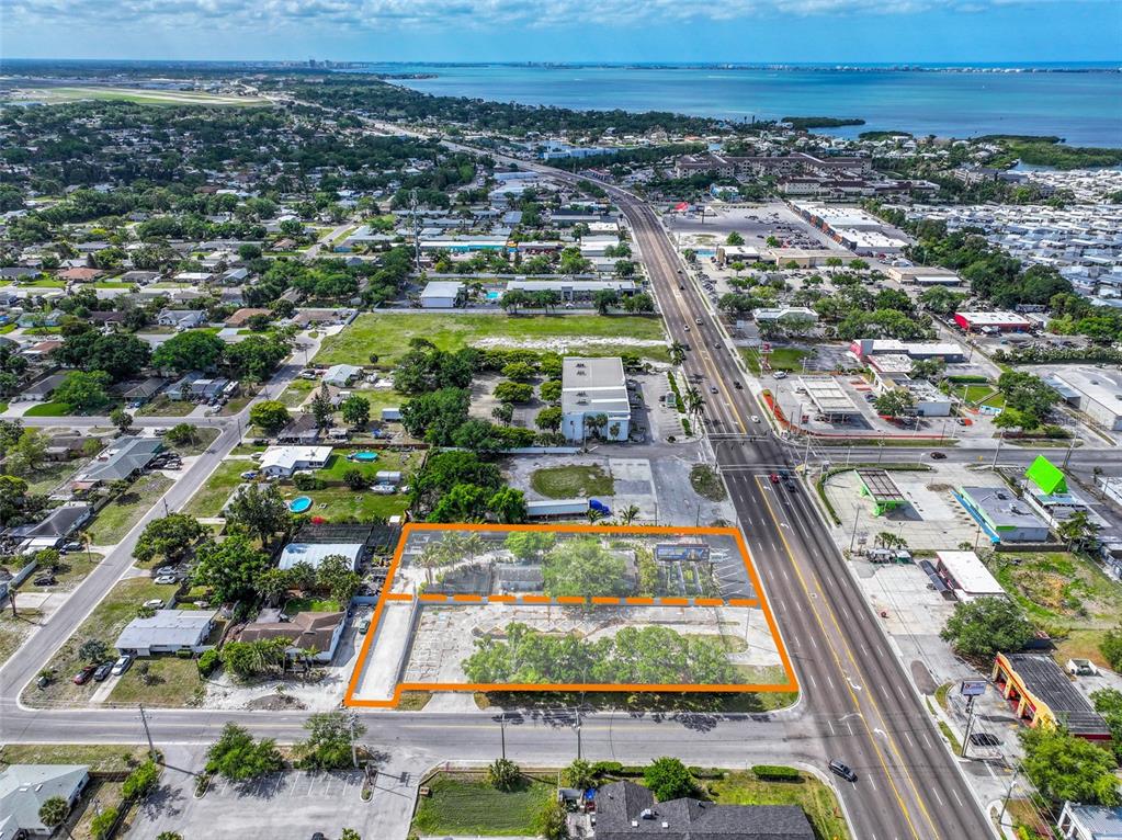 An aerial view shows a vacant lot and adjacent property outlined in orange along a road — 6605 14TH STREET W, BRADENTON, FL