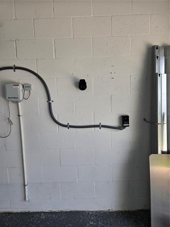 A garage wall features a Rain Bird irrigation controller and an electric vehicle charging outlet — 1677 BLUE ROSE DRIVE, RUSKIN, FL