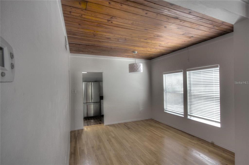 A dining room features a wood-plank ceiling, hardwood floors, and a view into the kitchen — 303 S OSPREY AVENUE UNIT 303, SARASOTA, FL
