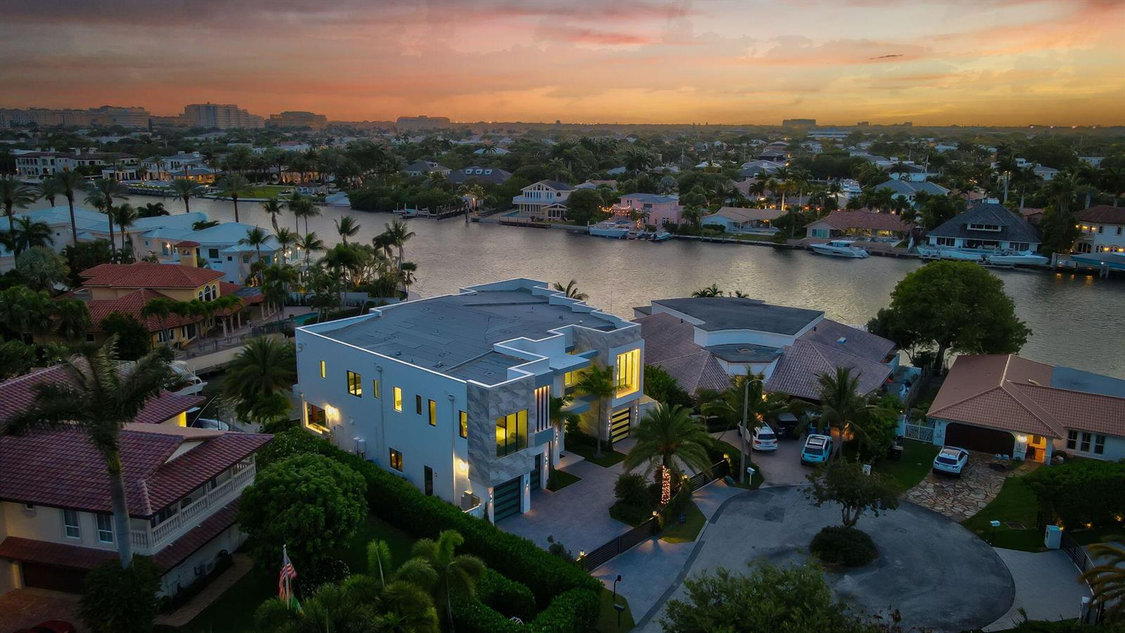 An aerial view of a modern two-story house with a flat roof beside a canal — 749 Bamboo Drive, Boca Raton FL 33432, BOCA RATON, FL