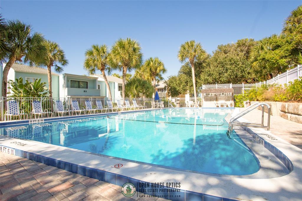 A rectangular outdoor swimming pool is surrounded by a brick deck and palm trees — 6300 A1A S UNIT B24U, ST AUGUSTINE, FL