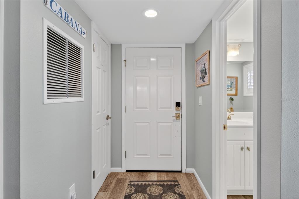 A hallway features a white door, a closet, a vent, and an adjacent bathroom entrance — 6300 A1A S UNIT B24U, ST AUGUSTINE, FL