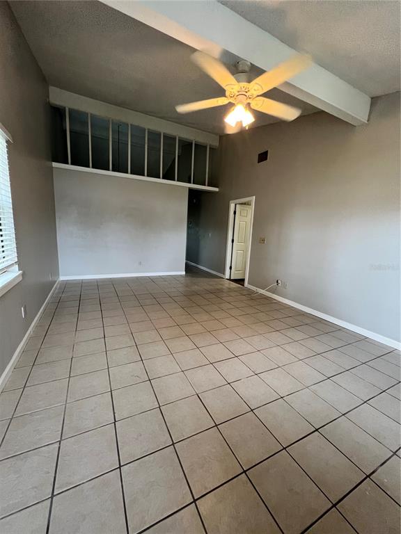 A room with light-colored tile flooring, a vaulted ceiling with a fan, and a loft area — 267 LAKE THOMAS DRIVE, WINTER HAVEN, FL