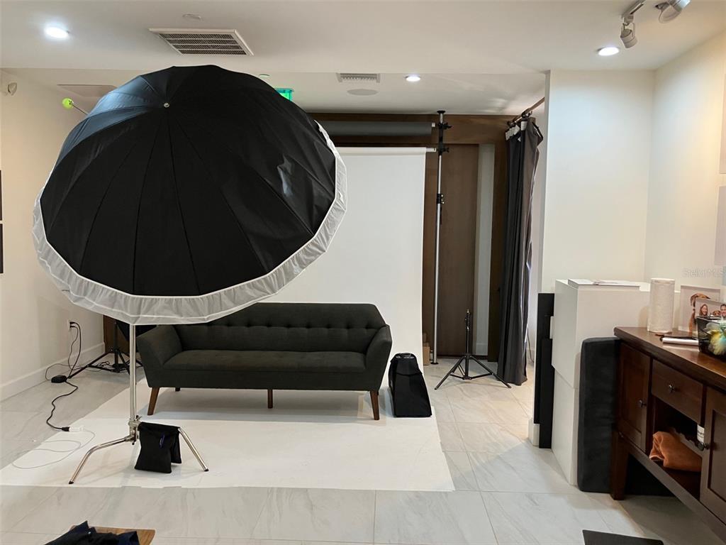 A room set up as a photography studio features a large umbrella light and sofa — 3105 W BAY TO BAY BOULEVARD, TAMPA, FL