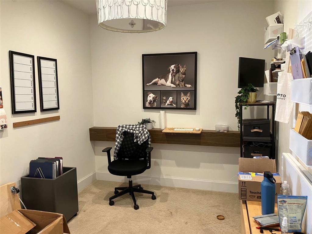 A home office features a floating wood desk, a black office chair, and wall art — 3105 W BAY TO BAY BOULEVARD, TAMPA, FL