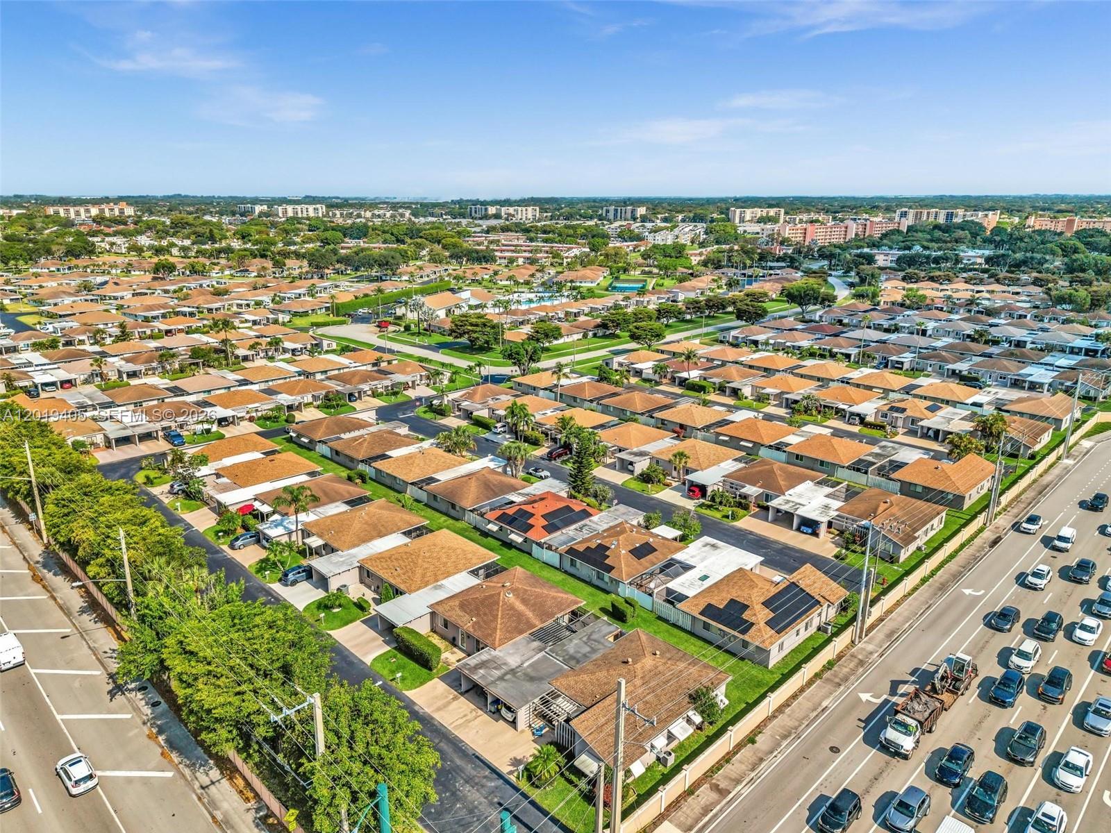 An aerial view shows a suburban neighborhood with rows of houses and a nearby road — 14898 Wildflower Ln, Delray Beach FL 33446, DELRAY BEACH, FL