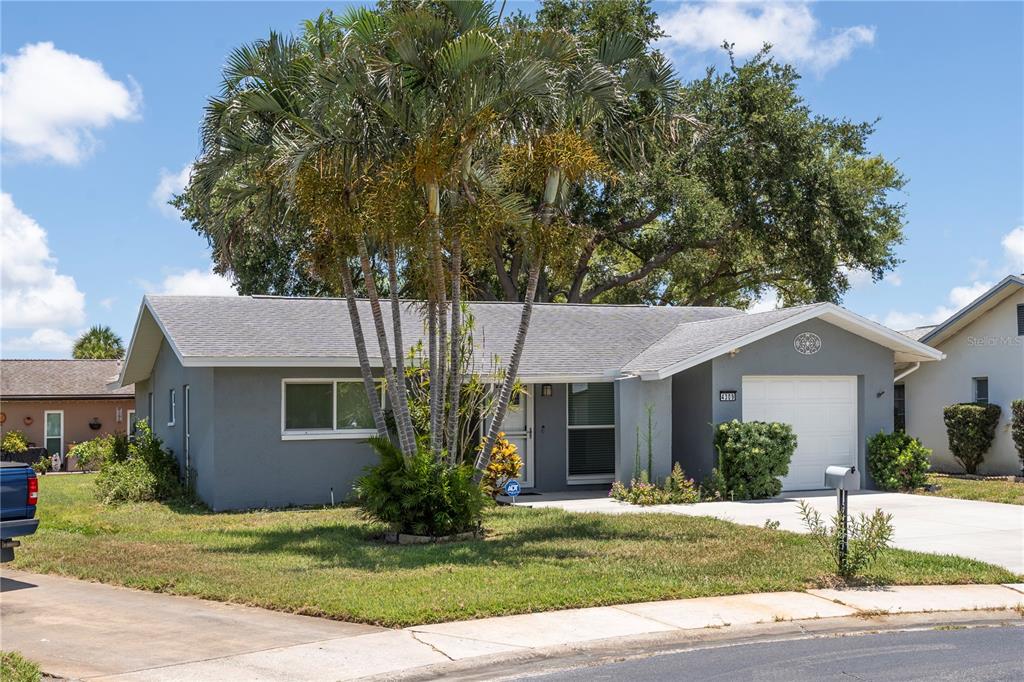 A single-story gray house with a white garage door and palm trees in the yard — 4309 HURON LANE, CLEARWATER, FL