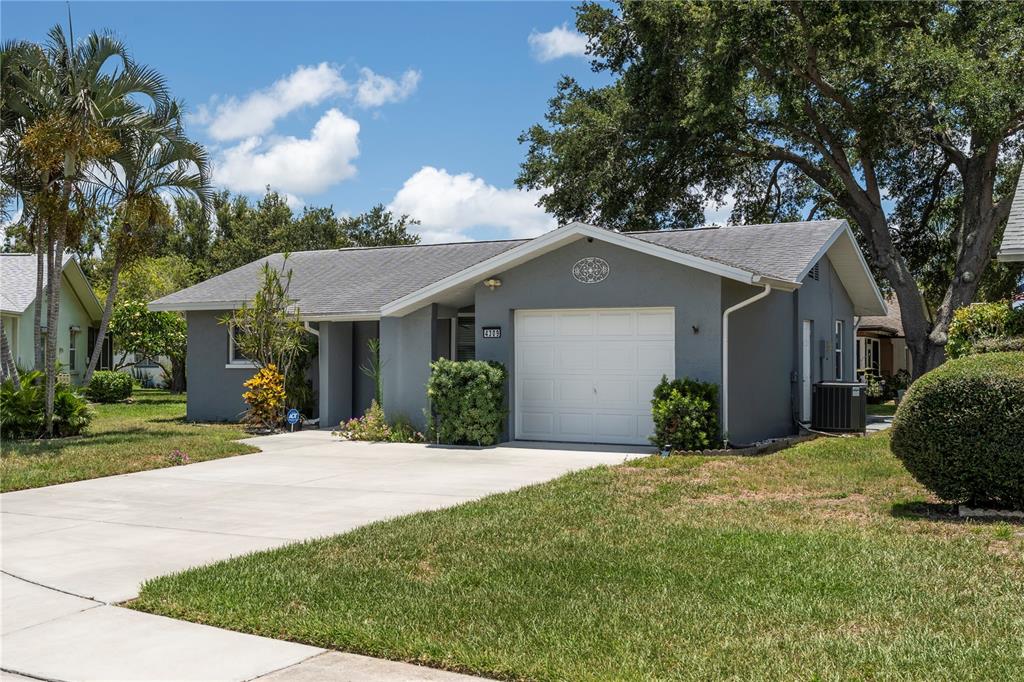 A single-story gray house with a white garage door and a concrete driveway — 4309 HURON LANE, CLEARWATER, FL
