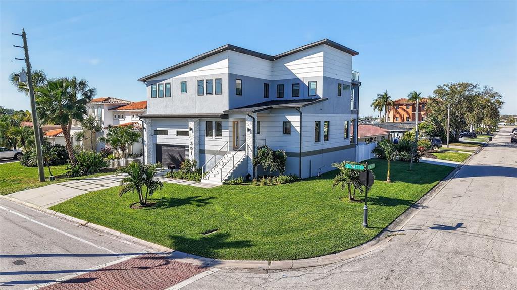 A modern two-story house with gray and white siding sits on a corner lot — 301 79TH STREET S, ST PETERSBURG, FL