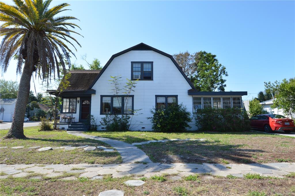 A white two-story house with a gambrel roof and a palm tree in the yard — 2800 DARTMOUTH AVENUE N, ST PETERSBURG, FL