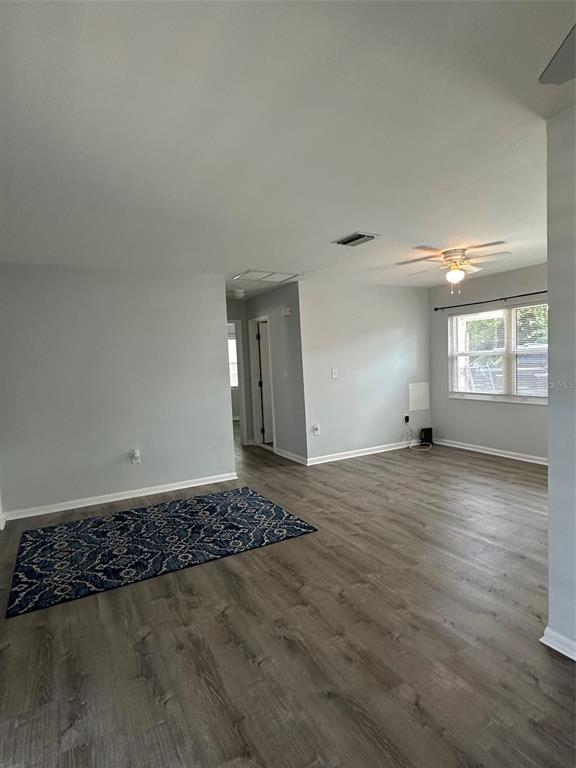 An open-concept living area features light gray walls, wood-look flooring, and a blue patterned rug — 155 DOW ROAD, PORT CHARLOTTE, FL