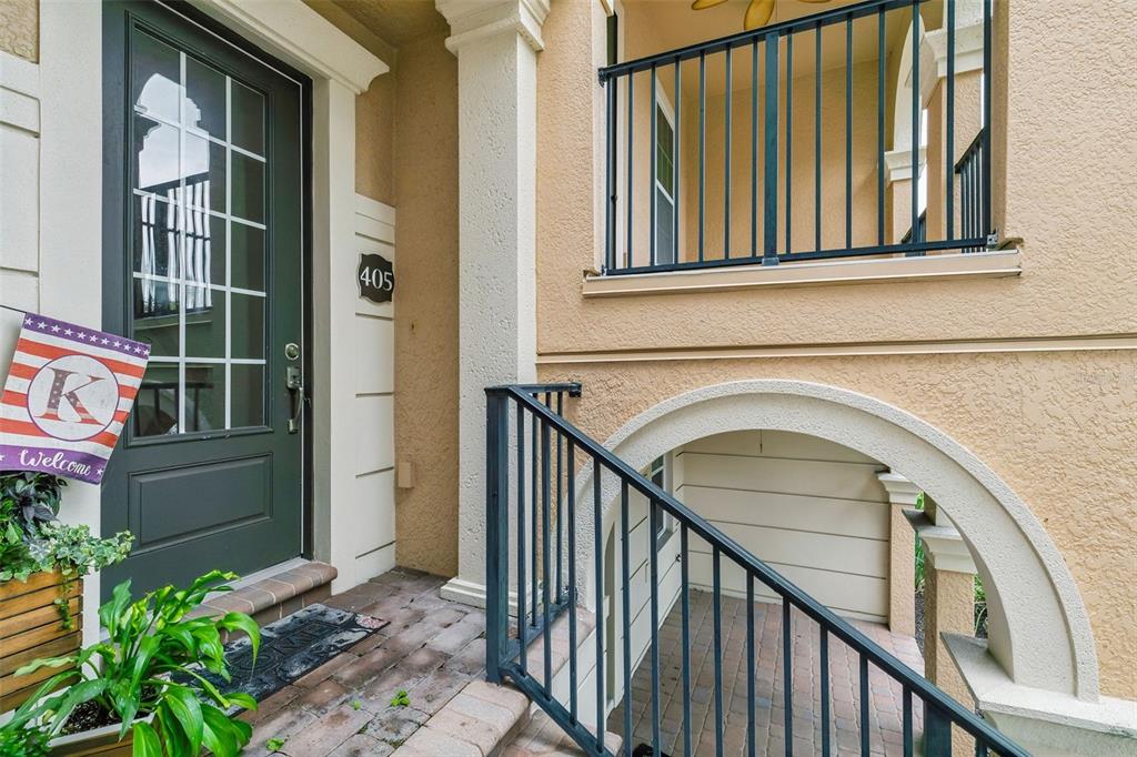 An exterior view shows a front door with a welcome sign and stairs leading downward — 405 PAVIA LOOP, LAKE MARY, FL