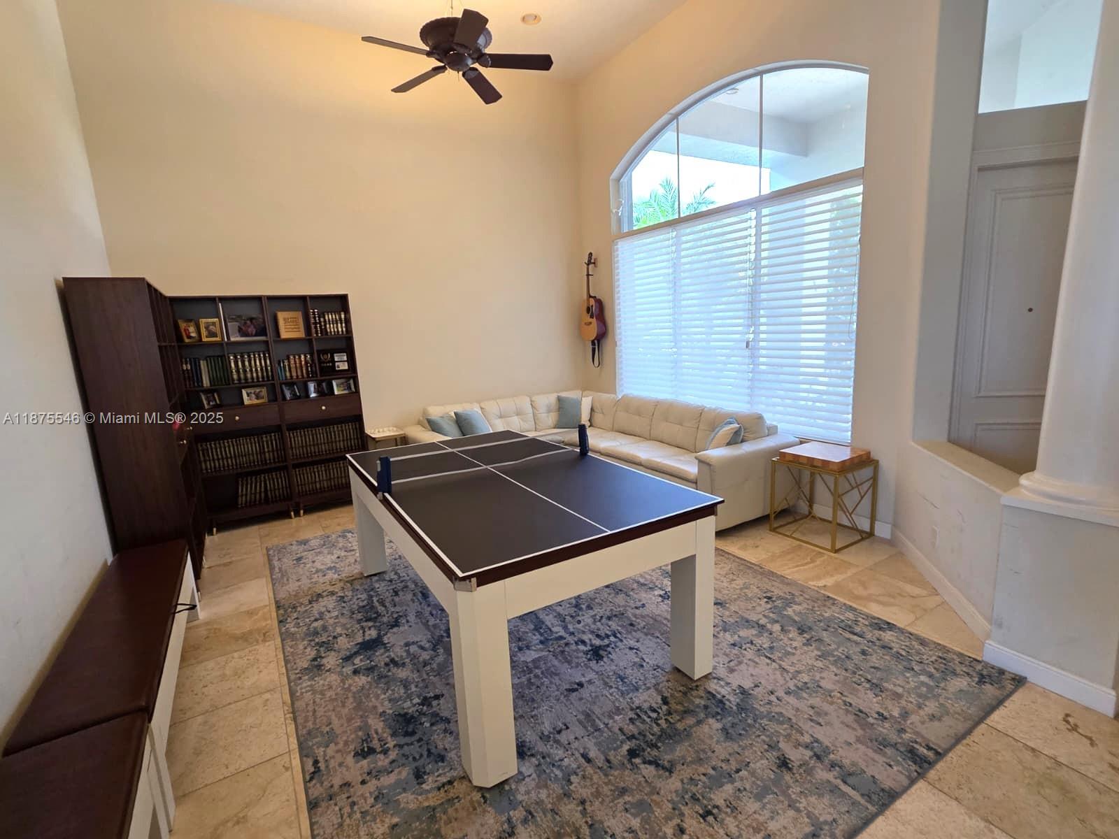 A living room features a ping pong table, a sectional sofa, and a tall bookshelf — 7030 Islegrove Pl, Boca Raton FL 33433, BOCA RATON, FL