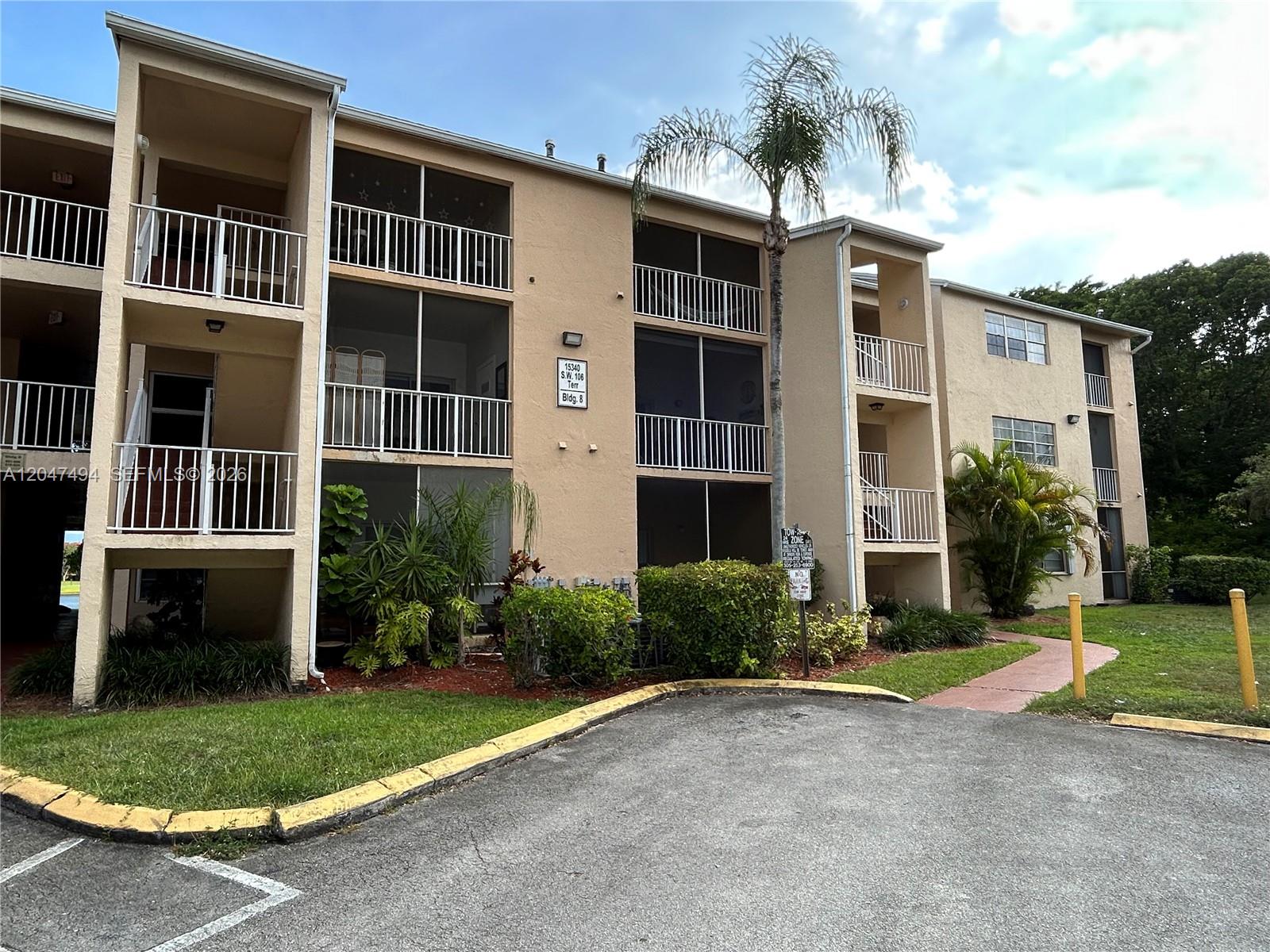 A three-story apartment building with screened balconies and a palm tree in front — 15340 SW 106th Ter # 817, Miami FL 33196, MIAMI, FL