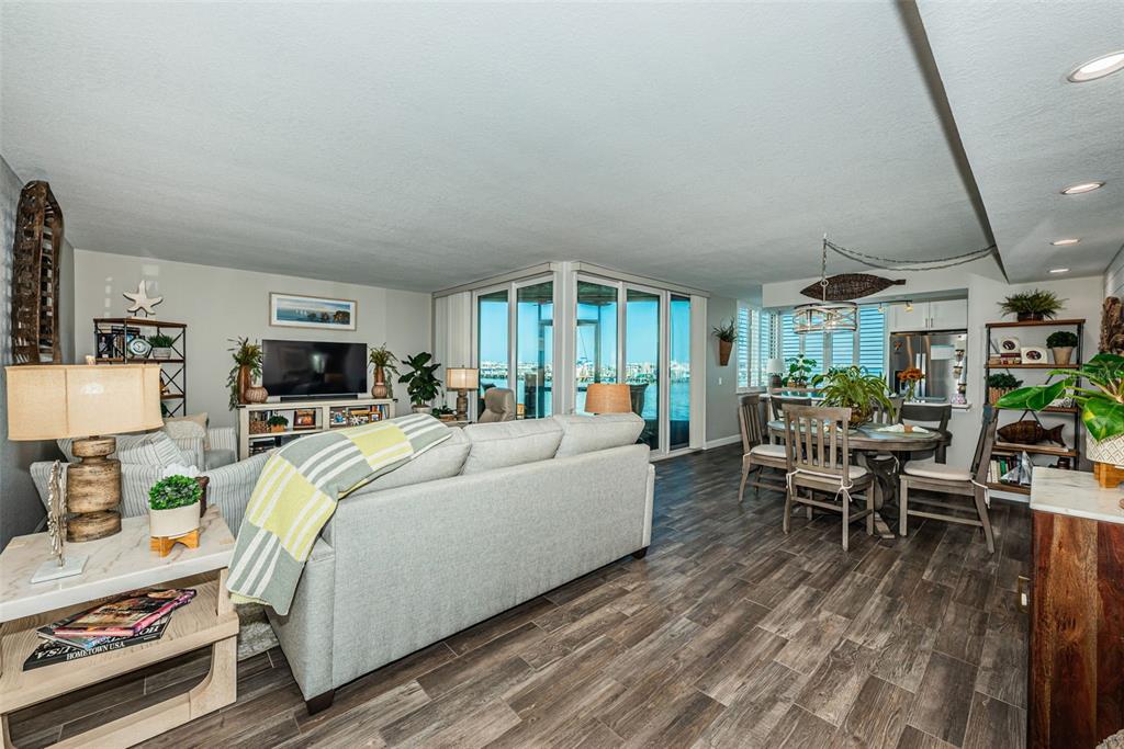 An open-concept living and dining area features wood-look flooring and a view of the water — 5825 PUERTA DEL SOL BOULEVARD S UNIT 166, ST PETERSBURG, FL