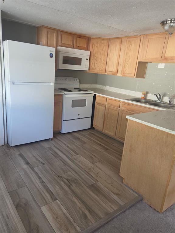 A kitchen with light wood cabinets, white appliances, and wood-look flooring — 906 ESTELLE AVENUE, BRANDON, FL