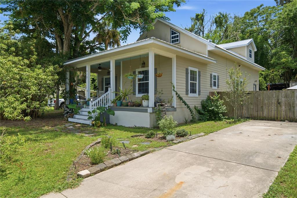 A tan, single-story house with a front porch and a concrete driveway — 512 SE 9TH STREET, OCALA, FL