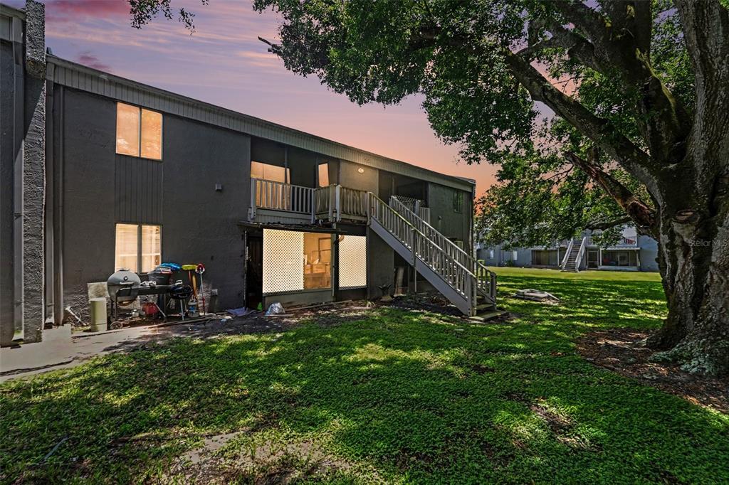 A two-story apartment building exterior features a wooden staircase leading to an upper balcony — 4008 CORTEZ DRIVE UNIT B, TAMPA, FL