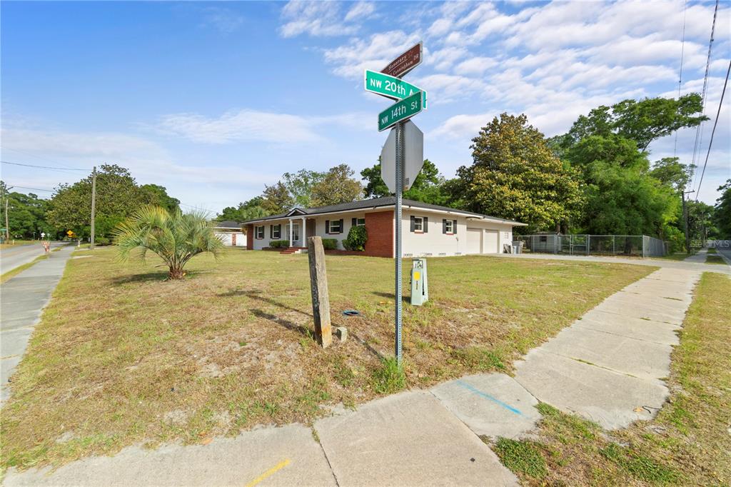 A single-story house with a brick facade and attached garage sits on a corner lot — 1910 NW 14TH STREET, OCALA, FL