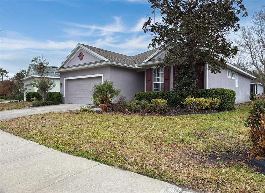 A single-story house with a gray exterior, a two-car garage, and a manicured front lawn — 109 AVENHAM DRIVE, DELAND, FL