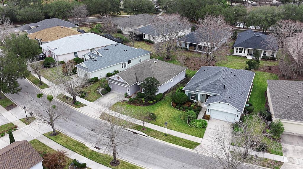 An aerial view shows several suburban houses with gray roofs and driveways along a street — 109 AVENHAM DRIVE, DELAND, FL