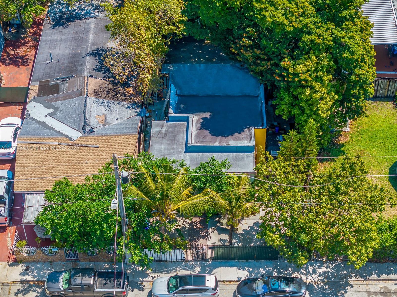 An aerial view shows a flat-roofed house surrounded by trees with cars parked on the street — 3123 NW 3rd Ave, Miami FL 33127, MIAMI, FL