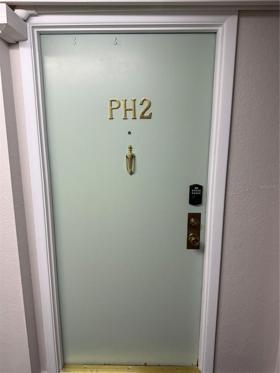 A light green door labeled PH2 features a gold knocker, peephole, and electronic keypad lock — 255 DOLPHIN POINT UNIT 2, CLEARWATER BEACH, FL